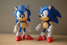 two toy sonic the hedgehogs standing next to each other
