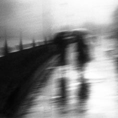 blurry image of two people walking on a bridge