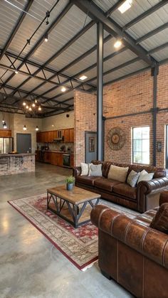 a living room with couches, chairs and a coffee table in front of a brick wall