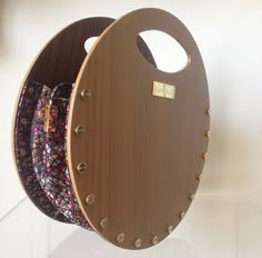 a round wooden object with metal studs on it's sides, hanging from the wall