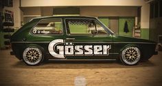 an old green car with the word gosser painted on it