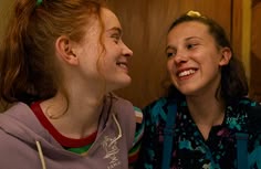 two young women are smiling and laughing together