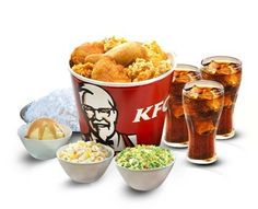 a bucket filled with lots of food next to two cups full of ice cream and soda