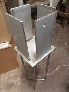 a metal object sitting on top of a table in a room with boxes and other items