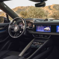 the inside of a car with dashboard, steering wheel and touch screen showing information about cars