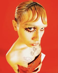 a woman with tattoos on her face and chest