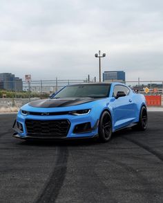 a blue chevrolet camaro is parked in a parking lot
