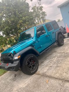 a blue jeep parked in front of a house