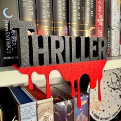 a book shelf filled with books covered in red and black letters that spell out the word thrilr
