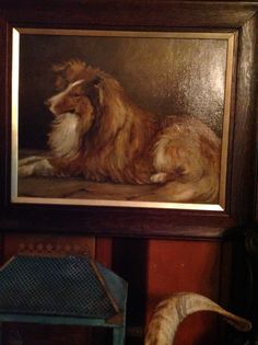 a painting of a dog is hanging on the wall