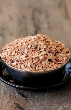 a black bowl filled with oats on top of a wooden table