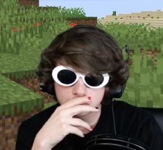 a young man wearing headphones and glasses in front of an image of a field