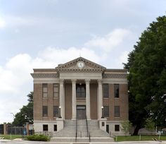 an old building with columns and a clock on the front