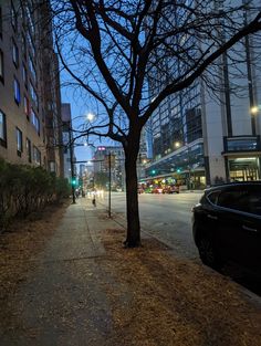 an empty city street at night with cars parked on the side walk and no one walking