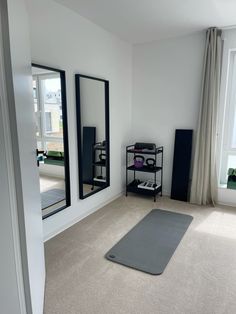 a yoga mat in the middle of a room with mirrors on the wall and floor