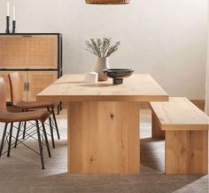 a wooden table with two chairs and a bowl on it in a living room area