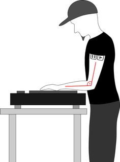 a man standing over a table with a laptop on it