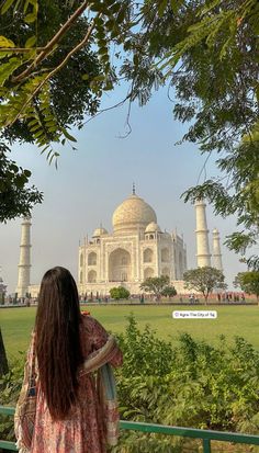 a woman standing in front of the tajwa mosque, with her back to the camera