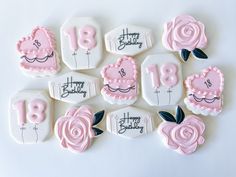 decorated cookies with pink icing and black lettering on them are arranged in the shape of roses