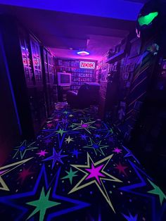 a room with stars on the floor and neon lights in the ceiling, along with bookshelves