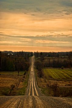 an empty dirt road leading into the distance