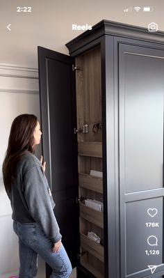 a woman standing in front of a tall cabinet