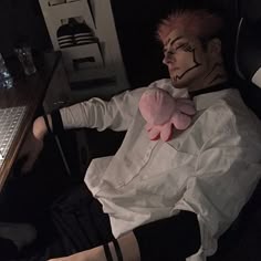 a man in white shirt laying on chair with stuffed animal