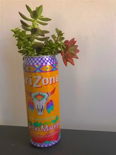 an orange can with some plants in it