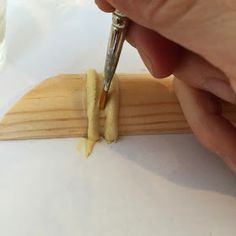 a person is using a pen to write on a piece of wood
