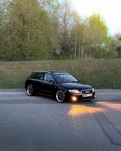 a black car is parked on the side of the road