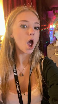 a woman making a surprised face with her mouth wide open in front of the camera