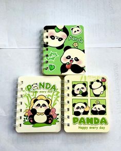 three notebooks with panda stickers on them sitting next to each other in front of a white background