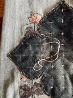 an old pair of jeans with embroidered flowers on them
