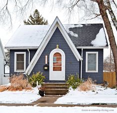 a blue house with snow on the ground
