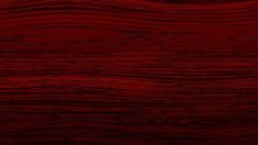 a red wood texture background that is very dark and has some light streaks on it