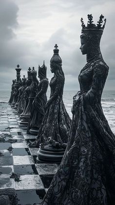 a row of chess pieces sitting on top of a checkerboard covered ground next to the ocean