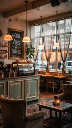 the interior of a coffee shop with chairs, tables and lights hanging from the ceiling