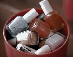 a red cup filled with different types of nail polish