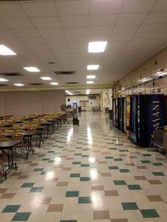 an empty cafeteria with tables and chairs in the middle of the room, all lined up against the wall