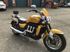 a yellow and black motorcycle parked in a parking lot
