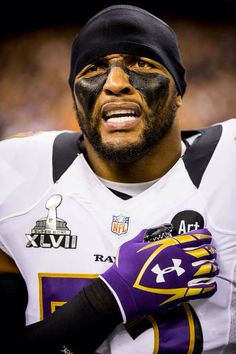 a close up of a football player with his face painted purple and gold on the side