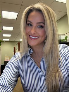 a woman with long blonde hair sitting in an office