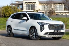 a white suv parked in front of a house