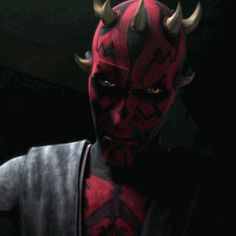 a close up of a person wearing a red and black costume with horns on their head