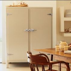 a kitchen with a table, refrigerator and chairs