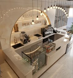 an open kitchen with lots of counter space and lights hanging from the ceiling above it