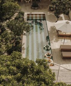 an aerial view of a pool with lounge chairs and umbrellas