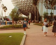 some people are walking around in front of the spaceship dome at disney's hollywood studios