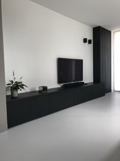 a large flat screen tv sitting on top of a black entertainment center in a living room