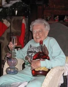 an old woman sitting in a chair holding a bottle